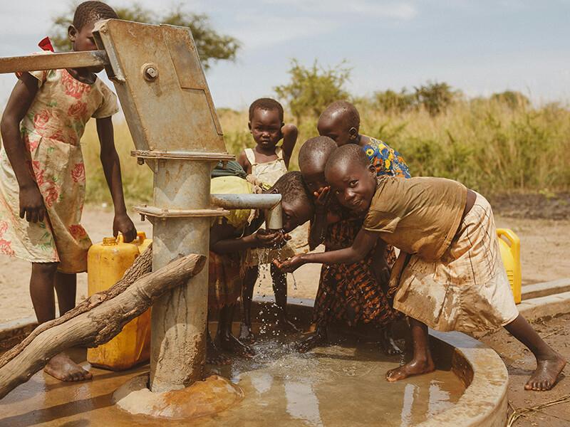 Children drinking clean water from a borehole